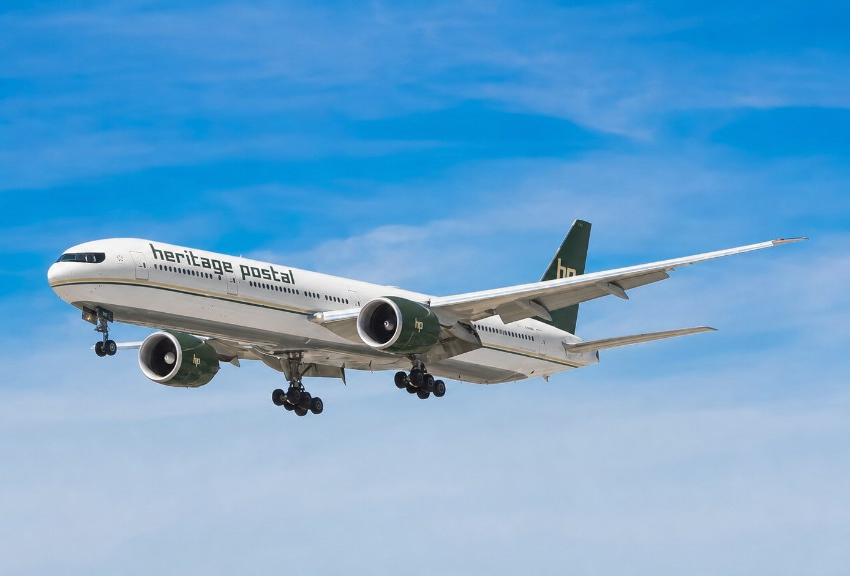 Heritage Postal branded aircraft in flight against a blue sky